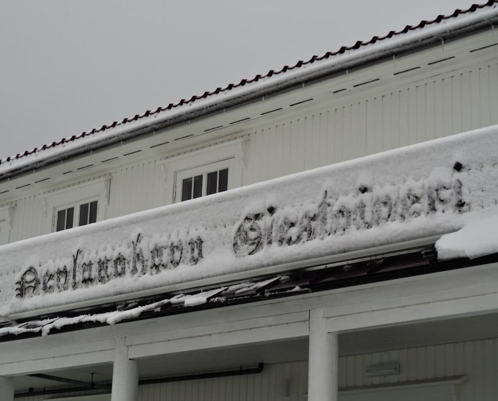 Nye skiltet og veggene til Nevlunghavn Gjestgiveri er snødekt